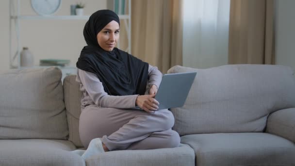 Aantrekkelijke Jonge Moslim Vrouw Dragen Hijab Zitten Gezellige Bank Woonkamer — Stockvideo