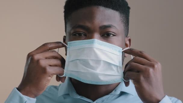 近视男性非洲商人美国成年男子戴上医疗面罩保护个人呼吸口罩防止考拉病毒感染捂住嘴看相机阻止世界大流行的概念 — 图库视频影像
