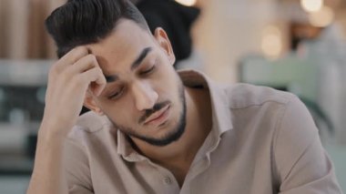 Stresli Arap sakallı Hintli adam gerilim stresinden muzdarip. Baş ağrısı, baş ağrısı, aşırı iş yorgunluğu. Yorgun çalışan, derin sıkıntılı düşünceler, üzgün patron.