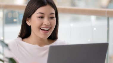 Bilgisayarlı bilgisayar oyunu oynayan Asyalı kız piyango hedeflerini kazanıyor. Finansal büyüme zaferi kutluyor. İyi haberler e-posta bankası onayı alıyor. Başarılı iş kadını mutlu çığlıklar atıyor.