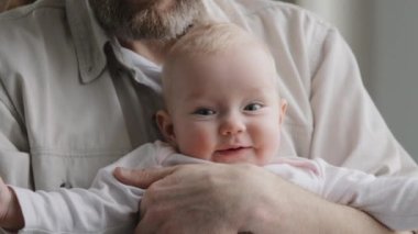 Duygusal şirin küçük çocuk yeni doğmuş küçük kız bebek kameraya bakıyor. Tanımlanamayan bir baba, çocuğunu kızına bağlıyor. Çocuk sağlığı çocuk sağlığı konsepti. Mutlu bebek yakın çekimi