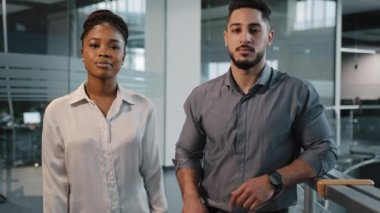 Ofis şirketinde iki ciddi çok ırklı ortak. Afrikalı iş kadını ve Hintli Arap iş adamı yöneticiler kameraya çapraz kollarla poz veriyorlar