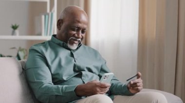 Afrikalı yaşlı, kel, yaşlı, yaşlı, yaşlı işadamı sinirli, emekli bir adamın internet üzerinden para transferi sorunu var. Banka hesaplarında telefon uygulaması ve kredi kartıyla ilgili bir sorun var.
