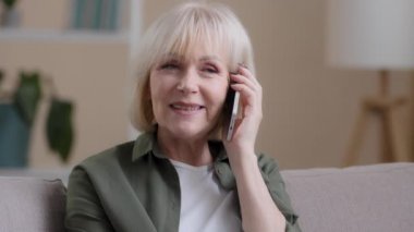 Yaşlı büyükannenin çocuklarla telefonda konuştuğu portre. Aile torunları evde. Yakın plan 60 'lı yaşlarda bir kadın arkadaşlarıyla konuşarak çağrıya cevap veriyor. Olgun bir kadın gezici bir konuşma yapıyor.