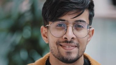 Erkek portresi genç yakışıklı, mutlu Hintli adam kameraya bakıyor gülümseyen dişlek, başarılı, kendine güvenen, sakallı adam modeli şık, hippi görünümlü, gözlüklü, içeride duran zeki öğrenci.