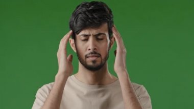 Genç Arap yerlilerinin erkek portresi. Sağlıksız, mutsuz, stresli, masaj yapan, baş ağrısı çeken, baş ağrısı çeken, migren şüphesi olan adam. Karmaşık bir karar.