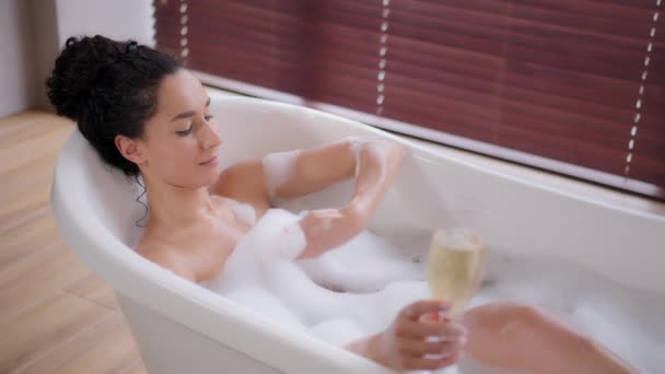 Jovem Mulher Brincalhão Relaxante Banho Quente Com Bolhas Segurando Champanhe — Vídeo de Stock