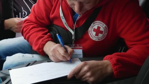 ハリコフ地域 ロガン ウクライナ 2022 赤十字の男性ボランティアは ウクライナの貧しい結果ひどい戦争をサポートするために慈善団体を支援する助けを必要とする人々のデータを書き込みます — ストック動画
