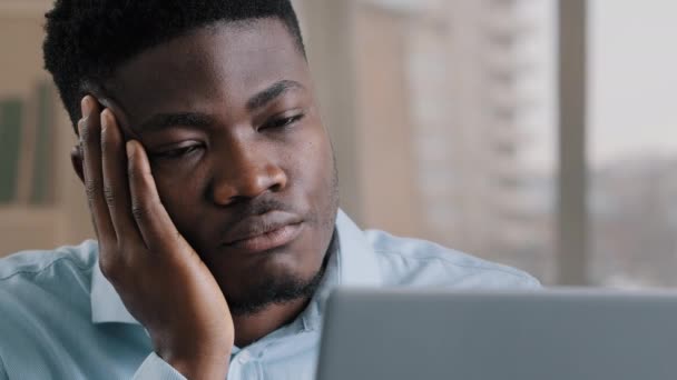 疲れ不幸なアフリカ系アメリカ人男性退屈を感じる受動的な感情悲しい怠惰な男疲れからハード残業モノトーンオンライン作業でコンピュータモチベーションの欠如精神保健問題うつ病 — ストック動画