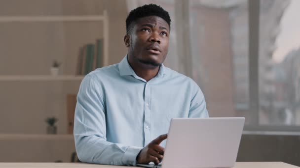 興奮したアフリカ人男性笑顔アメリカ人の男は コンピュータ上で毎日のタスクを行います問題解決策の思考の深さは 意思決定を思い出すメモリが最良のアイデアを思い付く答えを見つける計画を作成 — ストック動画
