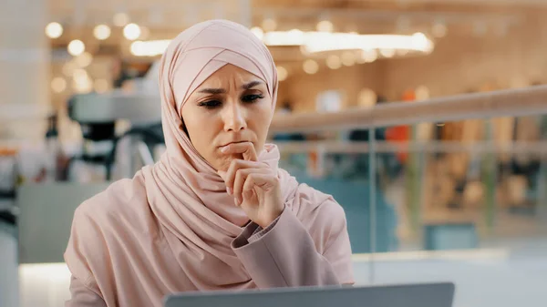 Young Pensive Puzzled Arab Woman Hijab Working Laptop Concentrating Idea — Stockfoto