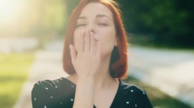 Mutlu, çekici bir kadının portresi kısa saçlı, stil sahibi, şehirde gülümseyen, güneş ışığında poz veren, el ele öpüşen, sevgi dolu, şefkatli, sevgi dolu bir kızın portresi.