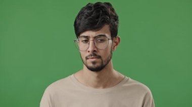 Clever arab man teacher in eyeglasses think hold hand on chin deep in thought indian guy student professor stand on green background fix spectacles generate idea dreaming smart face close-up portrait