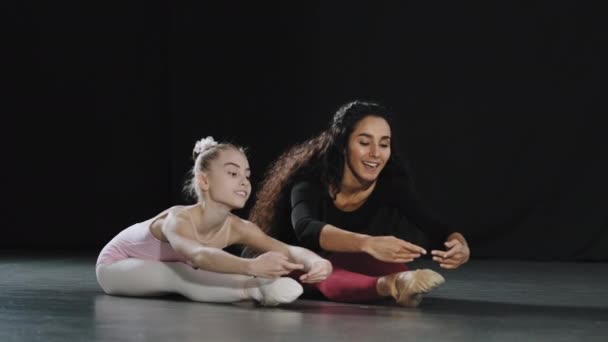 成人女教练女教师与女教师与少年女芭蕾舞演员一起坐在地板上舞蹈课 — 图库视频影像