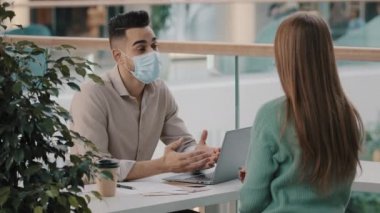 Tıbbi maske takan Arap patron İK yöneticisi kadın aday ile iş daveti için tokalaşıyor. Hintli erkek danışman erkek banka çalışanı kadın müşteriye el sıkışma sendikasına katılmasını tavsiye ediyor
