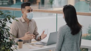 Man bank worker insurance agent man in medical mask advises consulting girl woman client about loan give cash money dollars credit shaking hands currency exchange financial services consultation. High