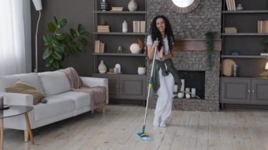 Genç, neşeli bir kadın oturma odasında yerleri temizliyor enerjik bir kızı heyecanlandırıyor. Komik hareketlerle dans ediyor. Eğlenceli ev idaresi müziğe geçiyor.