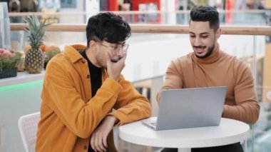 Young excited arab guy shows new project on laptop shocked man reading great news applauds support friend admires excellent result achievement expresses his opinion happy friends celebrating success