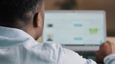 Bilinmeyen Afrikalı Amerikalı serbest yazar blogcu mavi gömlekli teknik yönetici bilgisayar siber uzay parşömeninde çalışıyor Wi-fi internet kullanarak web tasarım programı geliştiriyor