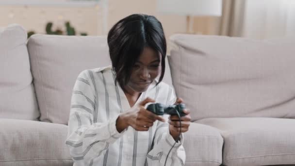 Young Focused Happy African American Woman Sitting Living Room Playing – Stock-video