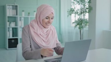 Arap iş kadını Müslüman çalışan yönetici İslami kız internet üzerinden iyi haberler okuyor. İnternette para kazanıyor. Banka başarısı elde etti.