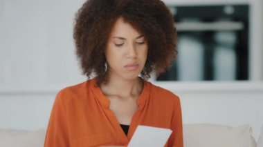 Heyecanlı kıvırcık saçlı, evinde kıvırcık saçlı, mektuplaşmış bir Afrikalı kadın. Mektupta iyi haberler okudum. Banka kredisinden olumlu ihbarlar aldım.