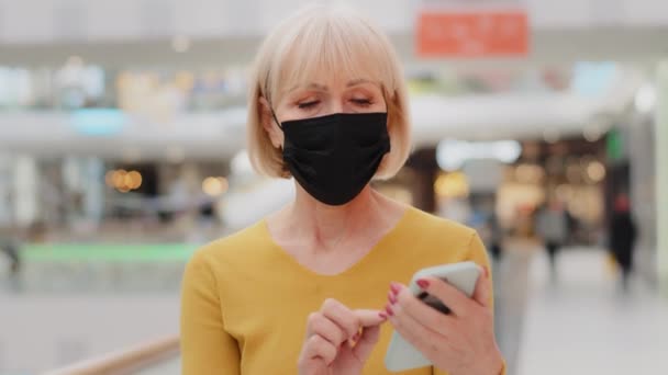 Mature Caucasian Woman Protective Mask Walking Indoors Focused Serious Middle — Stockvideo