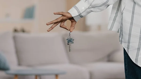 Close-up focus on apartment keys in hand of unrecognizable african american woman homeowner buying house mortgage bank client real estate agent realtor demonstrates advertises new modern apartments