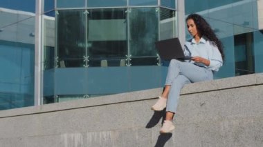 Genç başarılı kız öğrenci iş kadını kullanıcı uzaktan kumandalı uzaktan kumandalı bilgisayarla şehirde çalışıyor. İnternet uygulaması hizmetinde bilgisayar alışverişi yapan bayan istemci oturma geçmişi