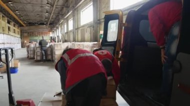 Kharkiv Kharkov region, Rogan, Ukraine - 05.10.2022: Red Cross volunteers in warehouse load boxes humanitarian aid in car for people in need during difficult time war social project help and support