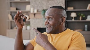 Mature african american man happy homeowner male realtor buyer showing bunch of keys from new estate apartment rented house excited happy adult senior grandfather win flat modern housing improvement