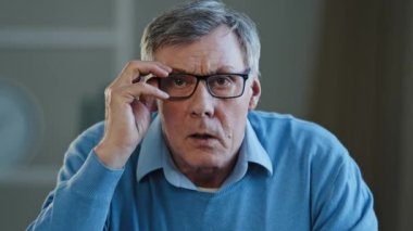 Kapalı portre şok edici Kafkas işadamı, üzgün yaşlı adam. 60 'lı yaşlarda, kafası şok olmuş, gözlük takan erkek. Kamera arızasına bakıyor, beklenmedik kötü haber.