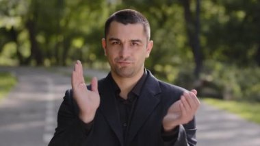 Doğa parkındaki beyaz, yakışıklı adam resmi siyah takım elbiseli başarılı iş adamı alkışlayan el ele tutuşan alkışlar yaparak hayranlığını dile getiriyor.