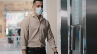 Arap İspanyol maske takan Hintli işadamı. Patron. Şirket ofisindeki yönetici. Asansör basma düğmesine gelen girişimci.