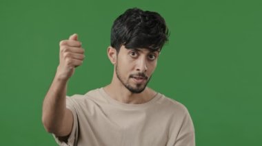 Misafirperver Hintli Arap adamın portresi davetkar bir el hareketi yap ve daha yakın gösterilere davet et. Yeşil stüdyo arka planında kameraya poz veren hoş geldin işareti.