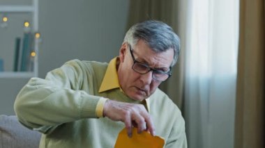 Disappointed sad upset shocked caucasian elderly male get official bank notification rejection read bad news in letter bankruptcy debt problem feel confused worried. Stressed mature man money troubled