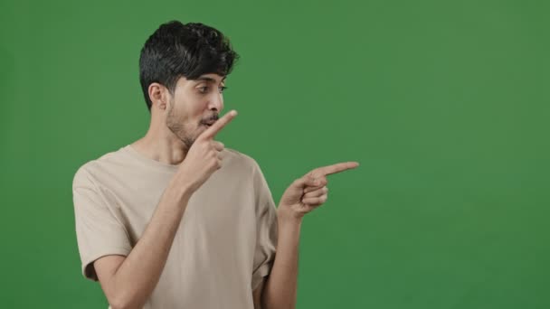 Optimistic Humorous Portrait Arabic Man Posing Green Studio Points Forefingers — стоковое видео