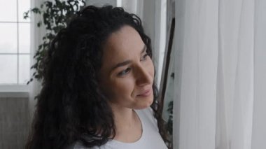 Close-up young happy woman looking out window admiring view smiling girl enjoying beautiful peaceful morning breathing fresh air rejoice in new day dreaming about future contemplates sunrise at home