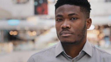 Successful confident young professional worker businessman turns to camera male model posing indoors happy joyful man smiling healthy toothy smile portrait of handsome african american guy close-up