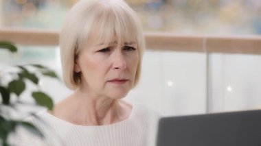 Close-up frustrated mature businesswoman looking at laptop screen reading email stunned shocked by unpleasant bad news emotion excited woman professional worker finds mistake in computer application