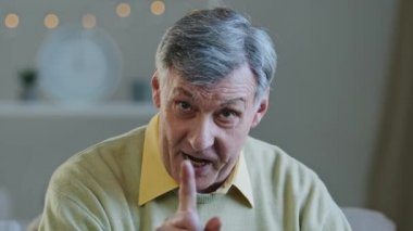 Close-up male portrait webcam view at home Caucasian angry mad elderly serious old man in glasses looking at camera shaking finger scolding upset talking explain irritation online conversation problem