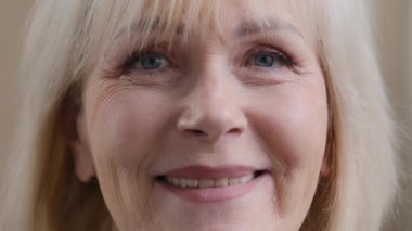Aşırı yakın plan Kafkasyalılar. 60 'lı yaşların kadın 50' li yaşların annesi. İçtenlikle gülümseyen dişlek, yaşlı, beyaz saçlı, olgun büyükanne.