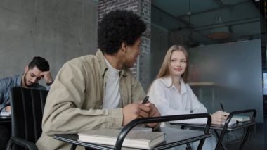 Students study in classroom group young happy people sitting at desk at lesson listening to lecture learning new topic communicate discuss teenagers smiling talking college higher education concept