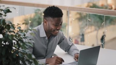 Young joyful man communicating via video call on laptop talking supports motivates to friend remote funny businessman speaking in online conference webinar laughing chatting on webcam friendly chat