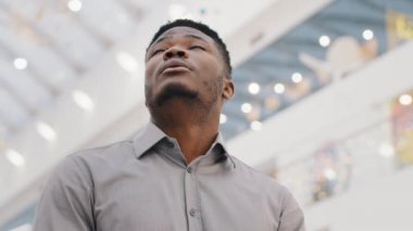 Close-up young shocked man looking around surprised male tourist surprising looks at architecture amazement stunned by scale building says wow emotional excited man standing indoor feeling enjoyment