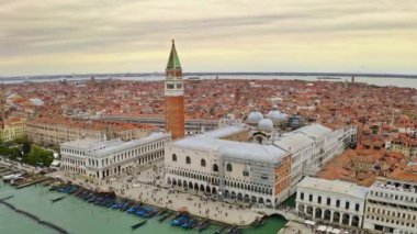 Aerial view historical attractions city of Venice in Italy Doges Palace famed San Marco public square Piazza Cathedral of Saint Mark large busy embankment with tourists famous tourist destination