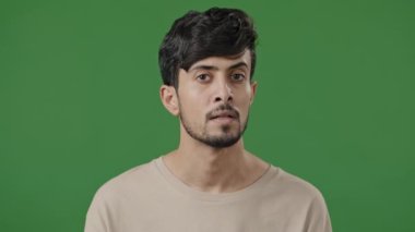 Arap genç adam olumlu kafa sallıyor onaylayıcı Latin özgüvenli adam yeşil arka planda duruyor evet destek jesti kabul işareti kabul ediyor.
