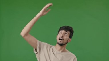 Stüdyo erkek portresi Arap Latin Latin genç esmer adam cazip bir jest yapıyor. Yukarıdan rica ediyor. Mucizevi bir şekilde inişe izin verilmesini bekliyor.