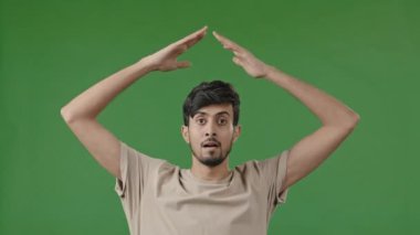 Hispanic young man arabian guy raise hands over head make house roof frame gesture with arms feel safe protection inside dream of home relocation housing rent new flat real estate insurance bank loan