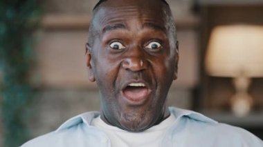 Şaşırmış erkek portresi şaşırmış Amerikan Afrikalı yetişkin adam 60 'ların kıdemli iş adamı evde dikilen büyükbaba şoku hisset.